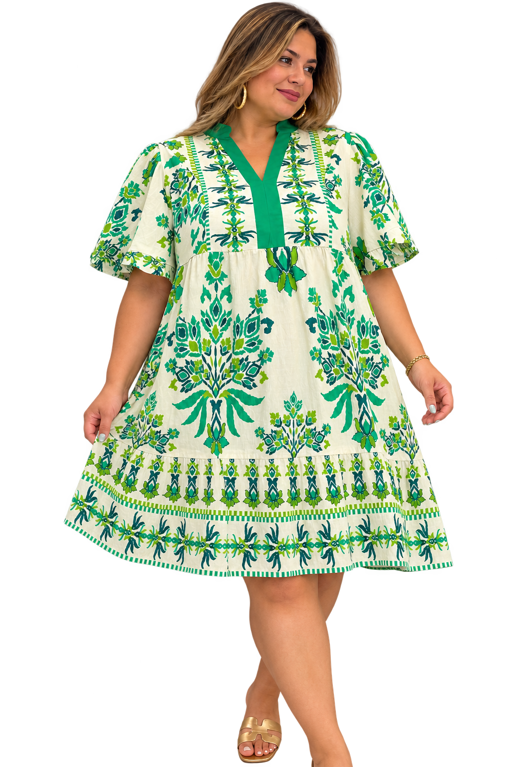 Plus-size model wearing ivory and green botanical print mini dress with flutter sleeves and tiered hem.