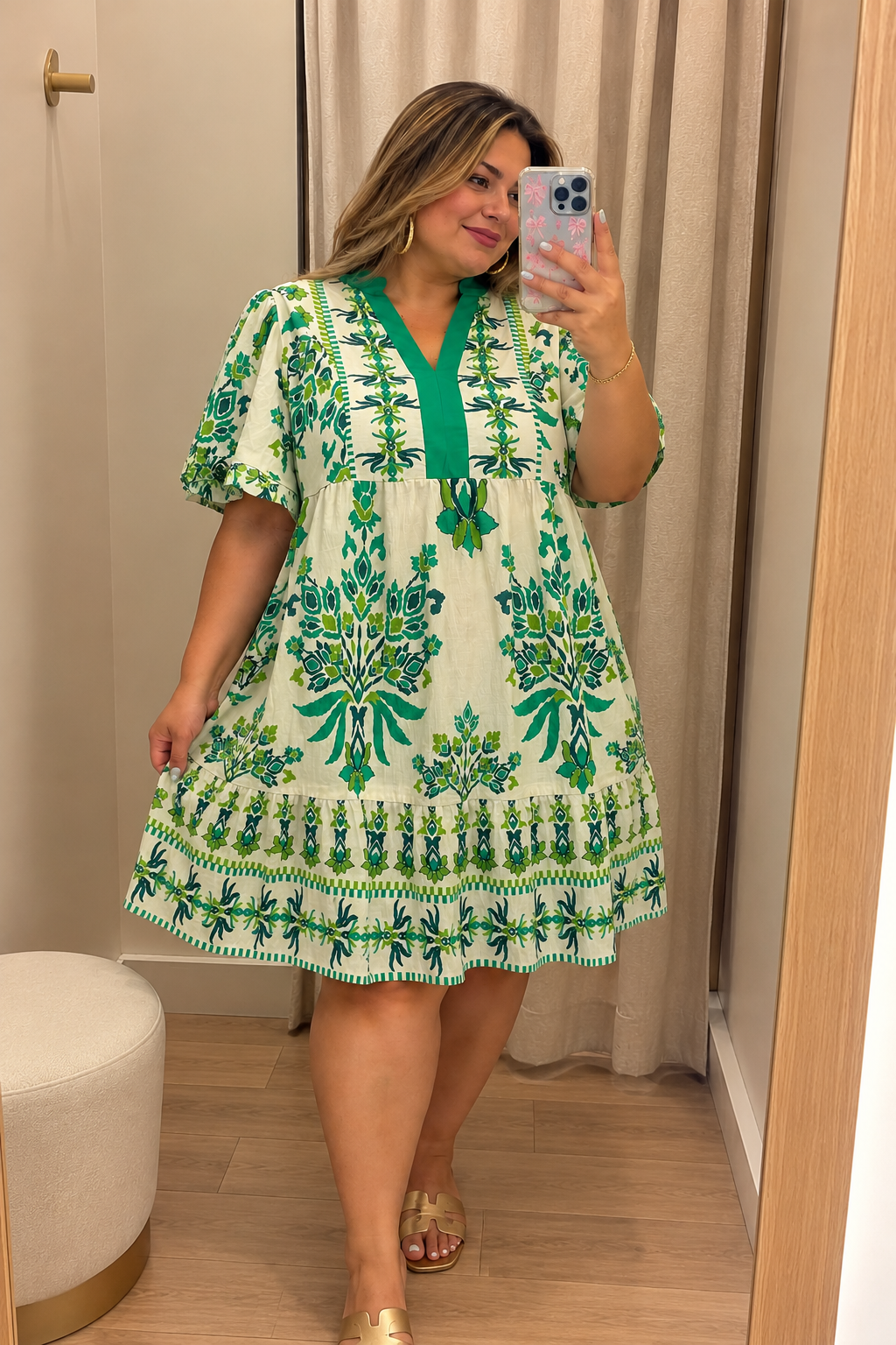 Plus-size woman taking a fitting room mirror selfie in the Emerald Garden Botanical Mini Dress.
